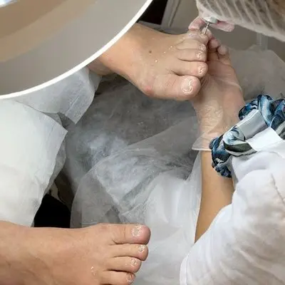 Podóloga realizando procedimento de cuidado das unhas em atendimento na Aos Pés Podologia